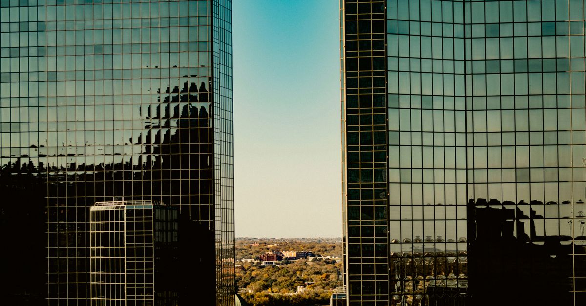A view of modern glass skyscrapers in Fort Worth, Texas, reflecting the skyline.