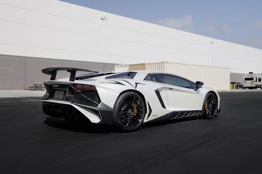 White Lamborghini sports car parked outdoors in an industrial setting.