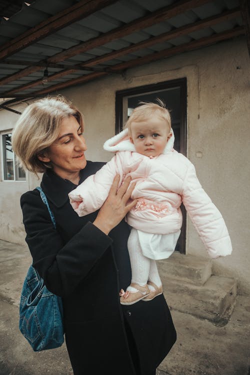 Mother in Black Blazer carrying a Child 