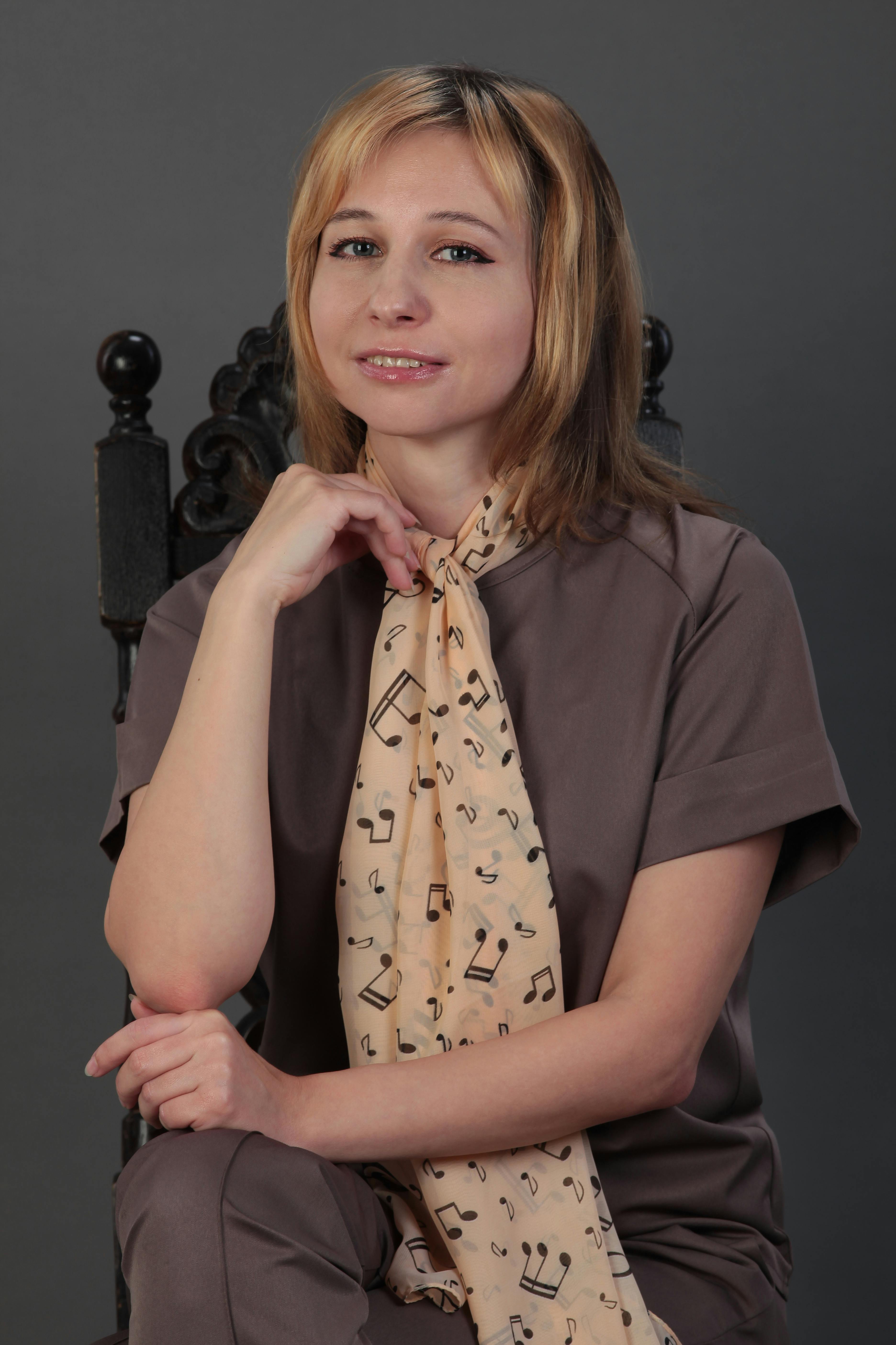 Portrait of a woman wearing a scarf with musical notes, exuding elegance and style.