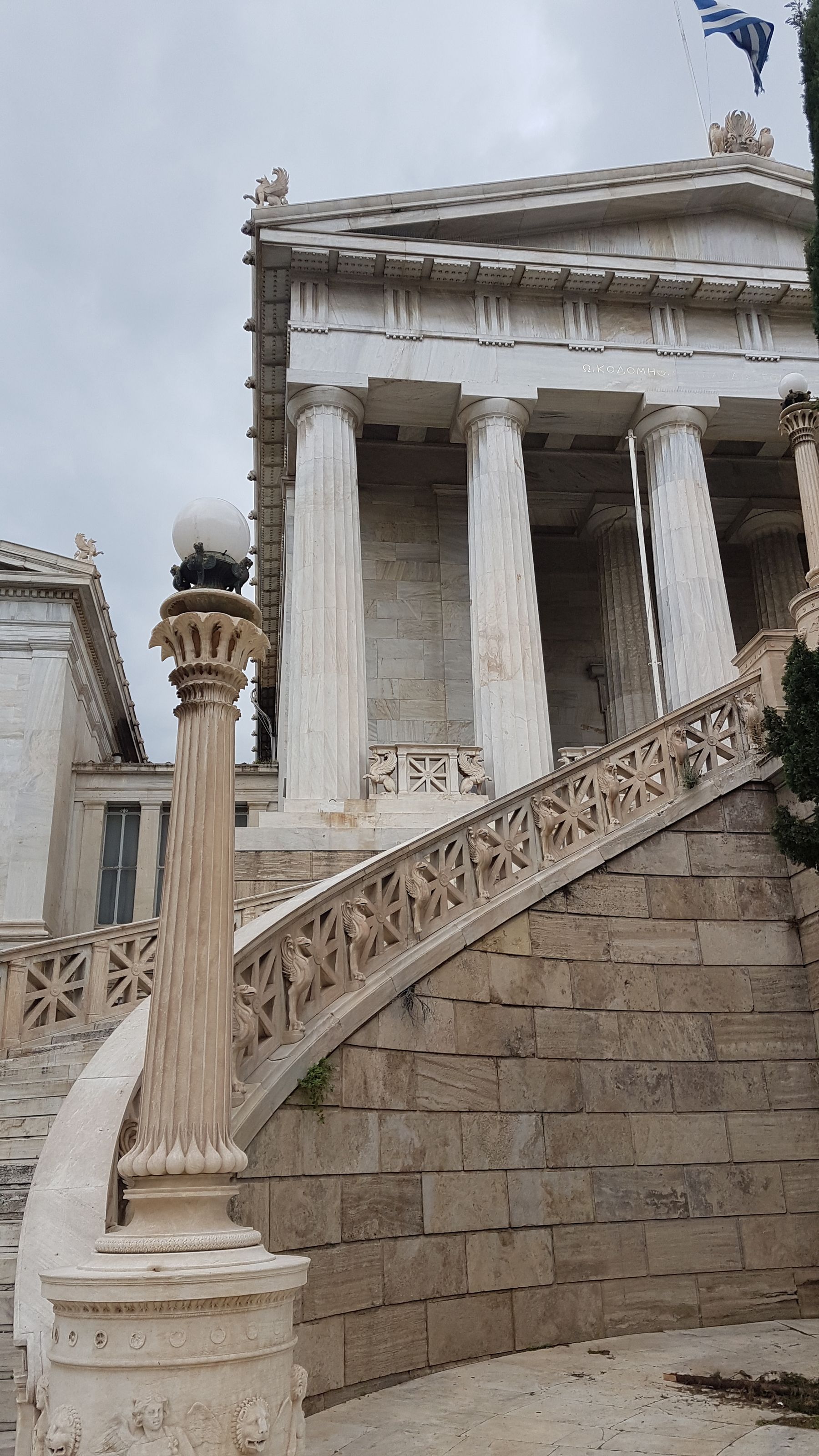 Marble columns and a carved stone stair rail on a neoclassical building