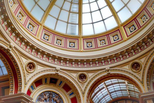 View of an ornate dome interior at an art museum in London, showcasing intricate details and relief carvings.
