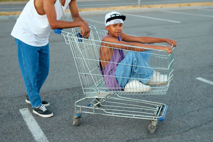 A Kid Sitting In A Shopping Cart