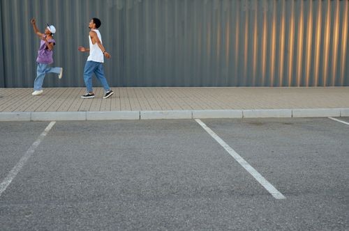 Free Two boys enjoying playtime on a sidewalk, capturing youthful energy. Stock Photo