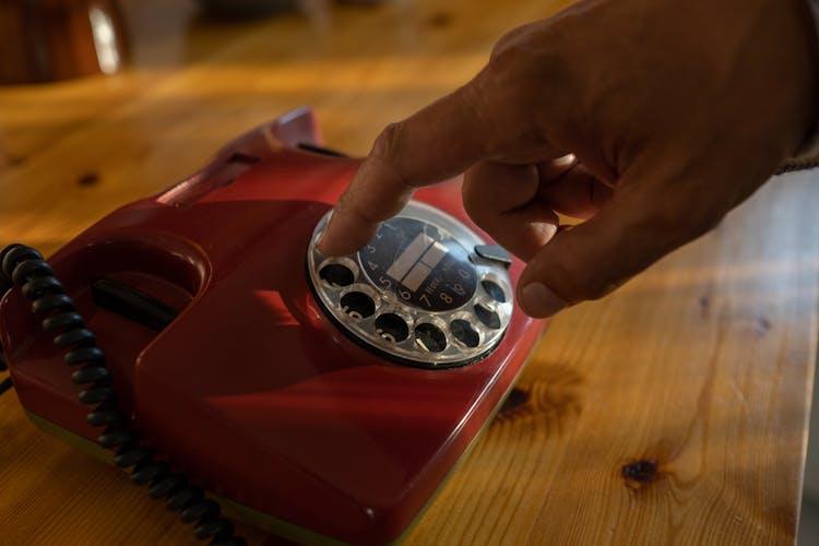 Close-up Of Mans Hand Dialing On Rotary Phone