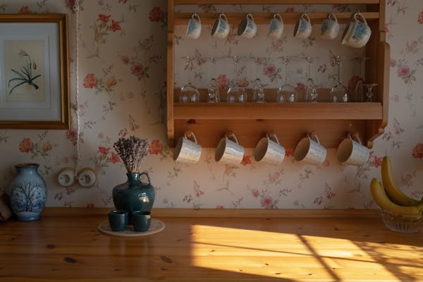 wall with vintage wallpaper and hanging china cups