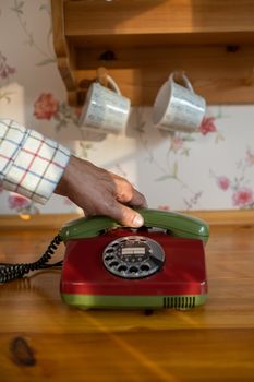 Close-up of Mans Hand Reaching for Telephone Receiver