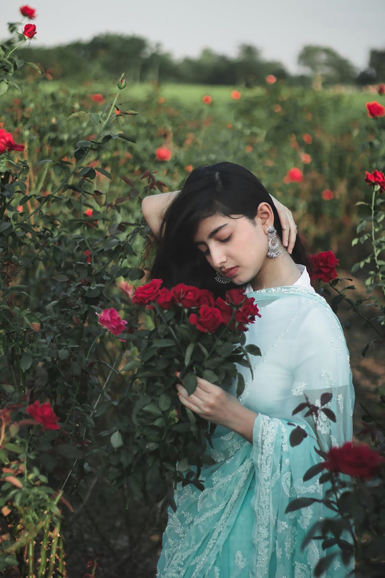 A Woman Smelling The Red Roses