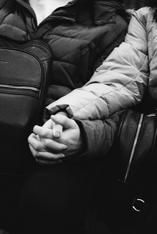 Grayscale Photo of Two People Holding Hands