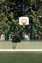 Red Basketball Hoop on Green Metal Fence