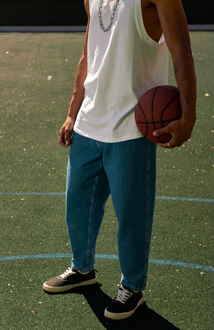 A Person Wearing White Tank Top Holding A Ball