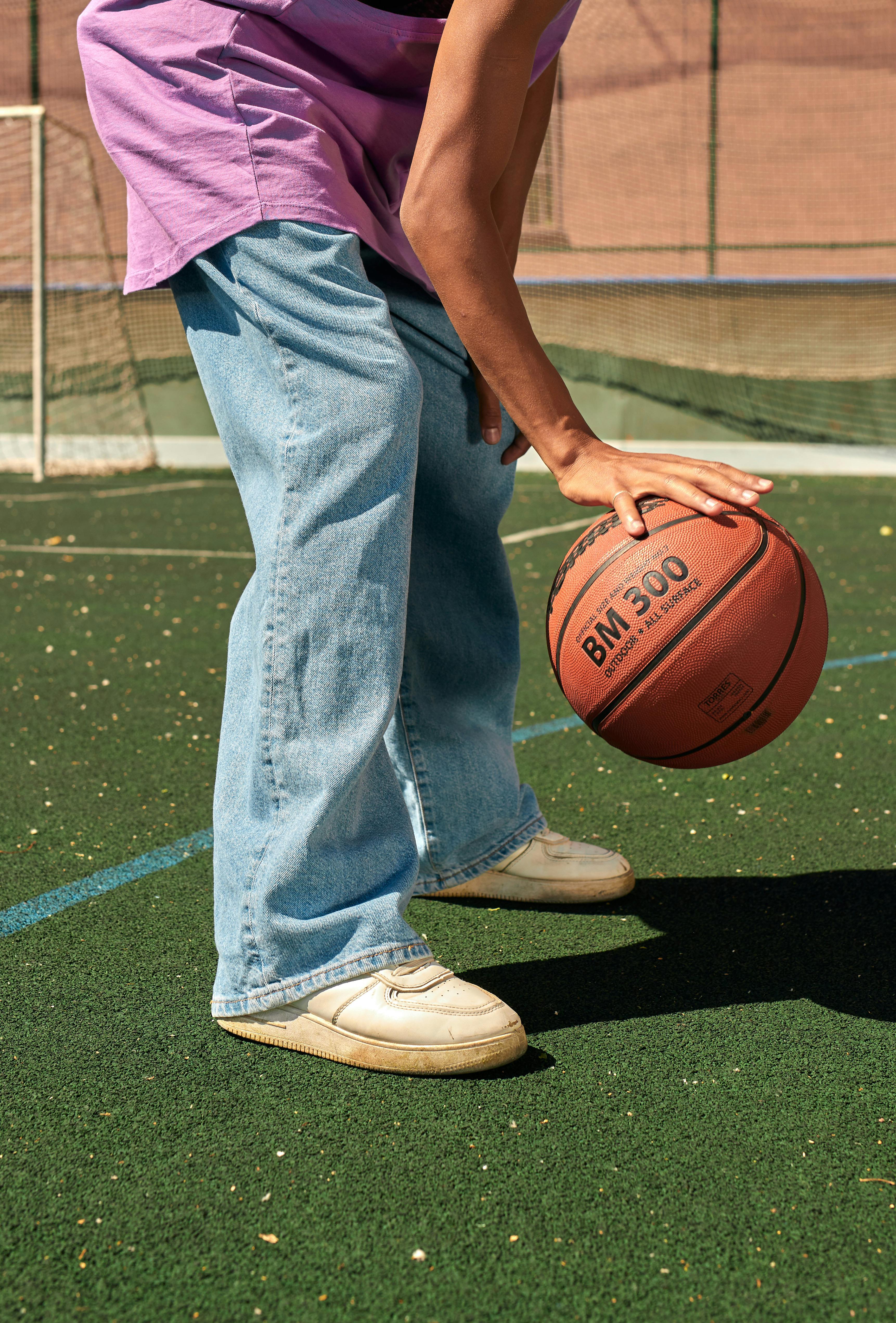 person in denim jeans dribbling the ball