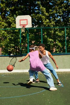 Two men playing basketball energetically on an outdoor court.