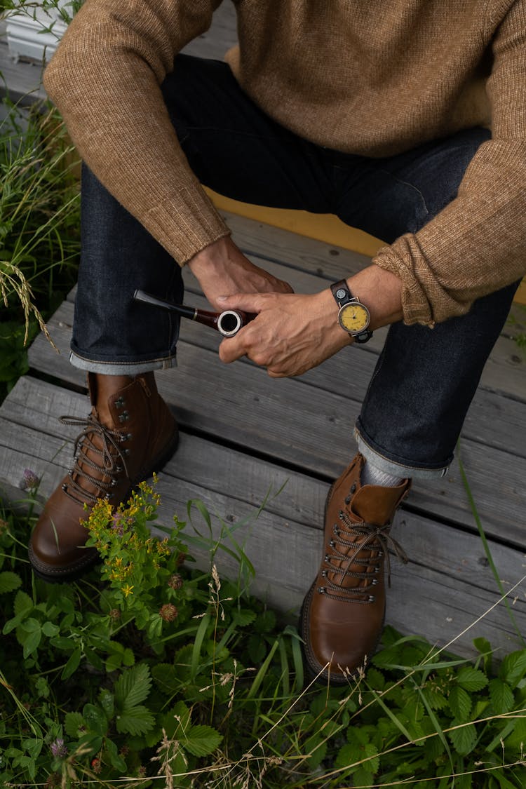 Elderly Man Sitting On Porch Holding Pipe