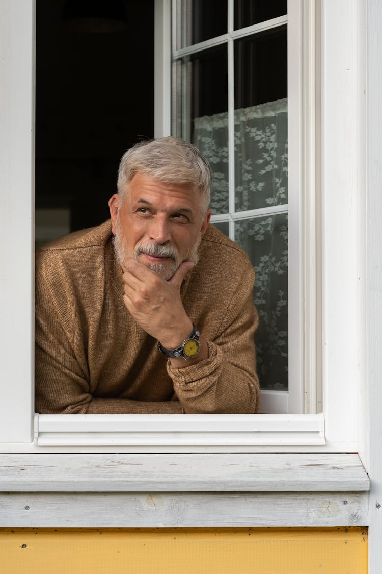 Elderly Man Leaning Out Of Window