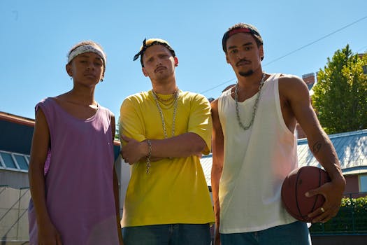 Three young men posing confidently on a sunlit basketball court.