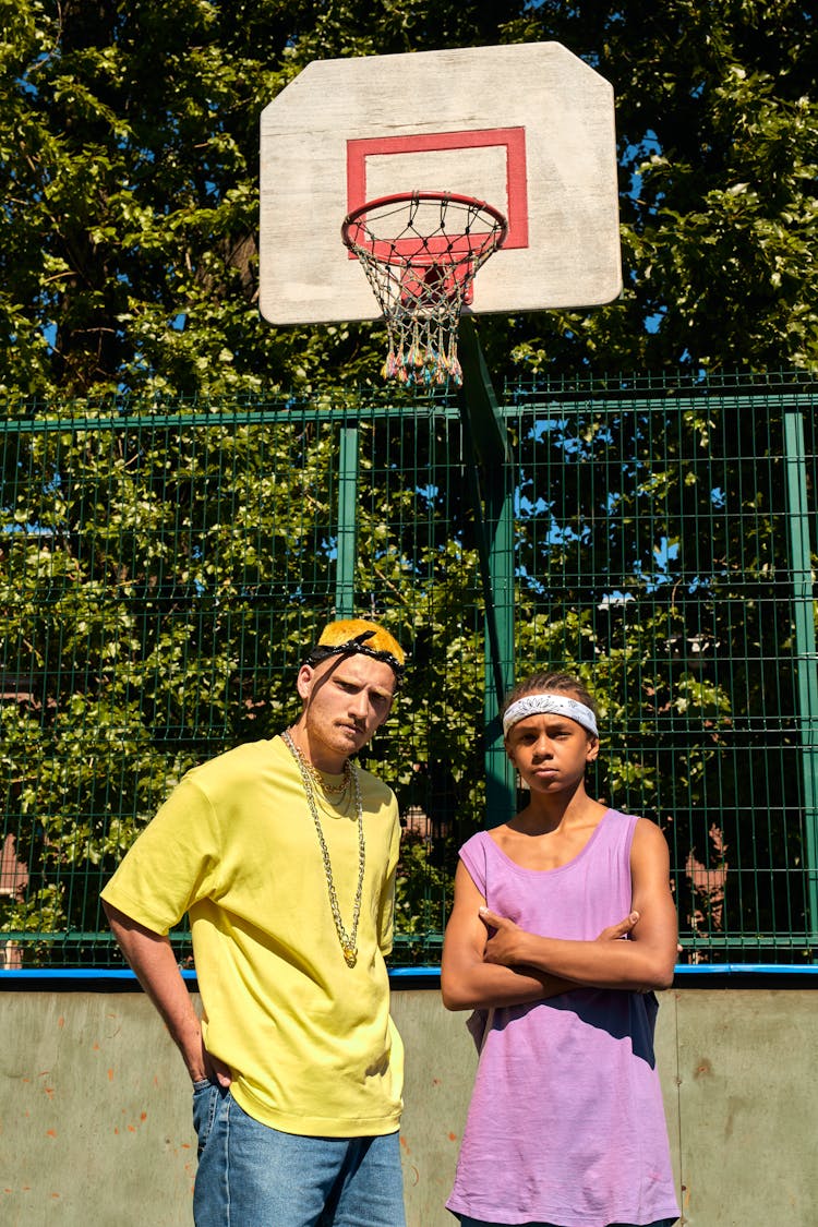 Man In Yellow Crew Neck Shirt Standing Beside The Boy In Purple Tank Top