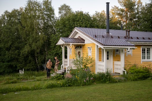 A tranquil scene of a grandfather and grandson outside a charming yellow house in summer.
