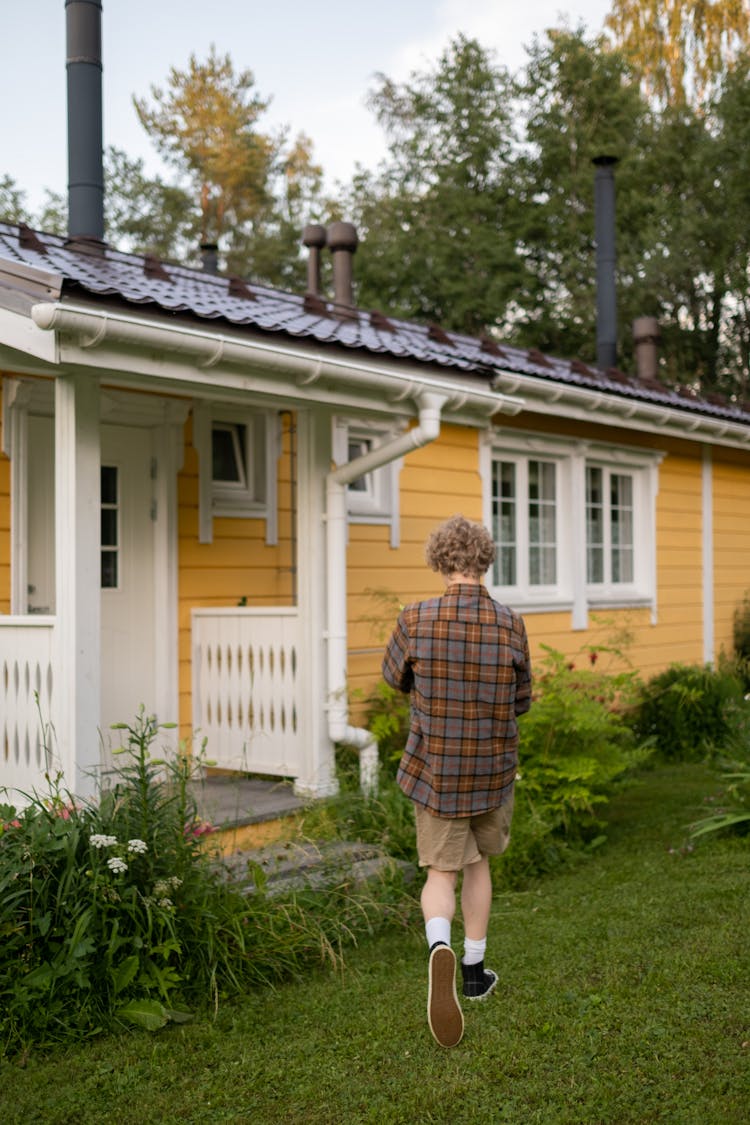 Teenage Boy Walking Into Country House 