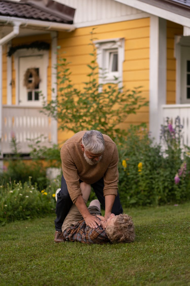 Grandfather And Grandson Playing On Grass