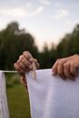 Close-up View of Hands Holding Laundry and Clamp