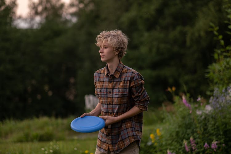 Portrait Of Teenage Boy In Shirt Holding Frisbee