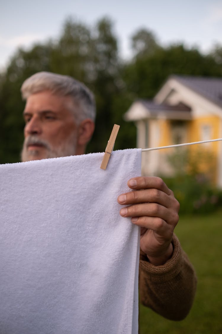 Elderly Man Hanging Up Laundry