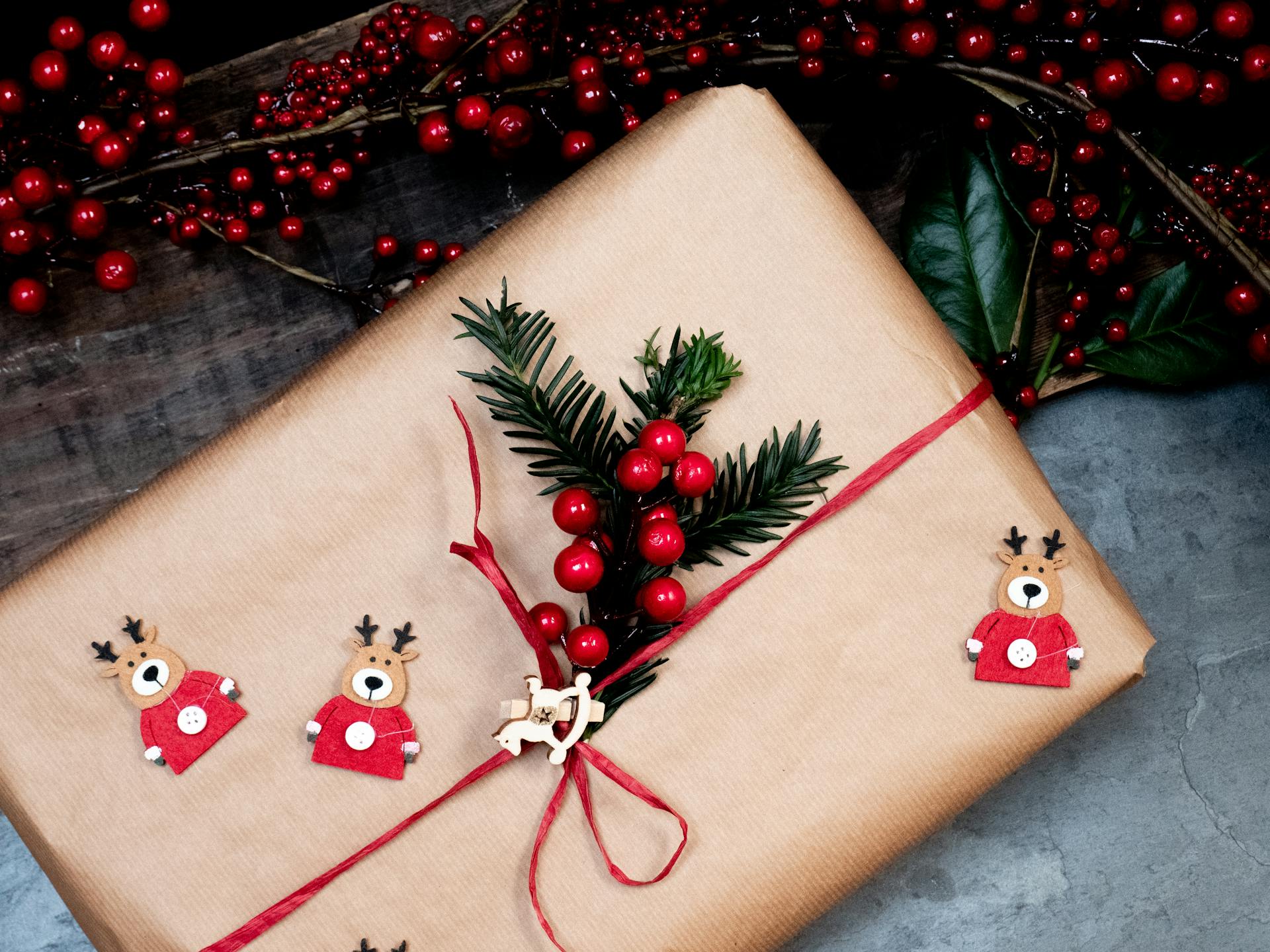 Beautifully wrapped Christmas gift adorned with red berries and festive decorations.