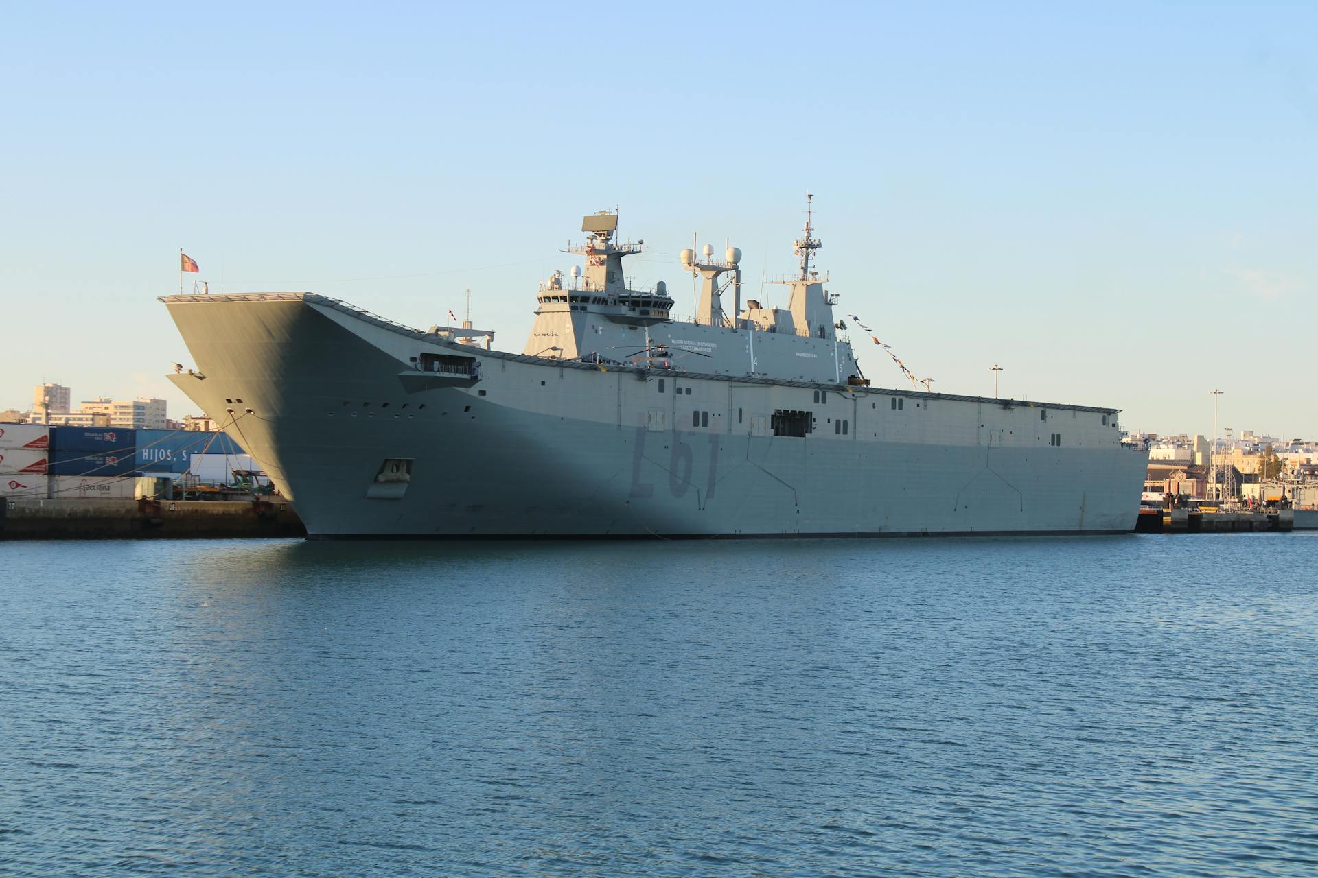 A naval ship moored at a dock in clear, sunny conditions at El Puerto de Santa María.