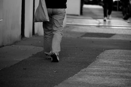Person Walking on Concrete Pavement 