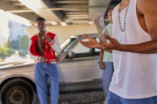 Young Man with a Bundle of Cash in His Hand after a Transaction Under the Bridge