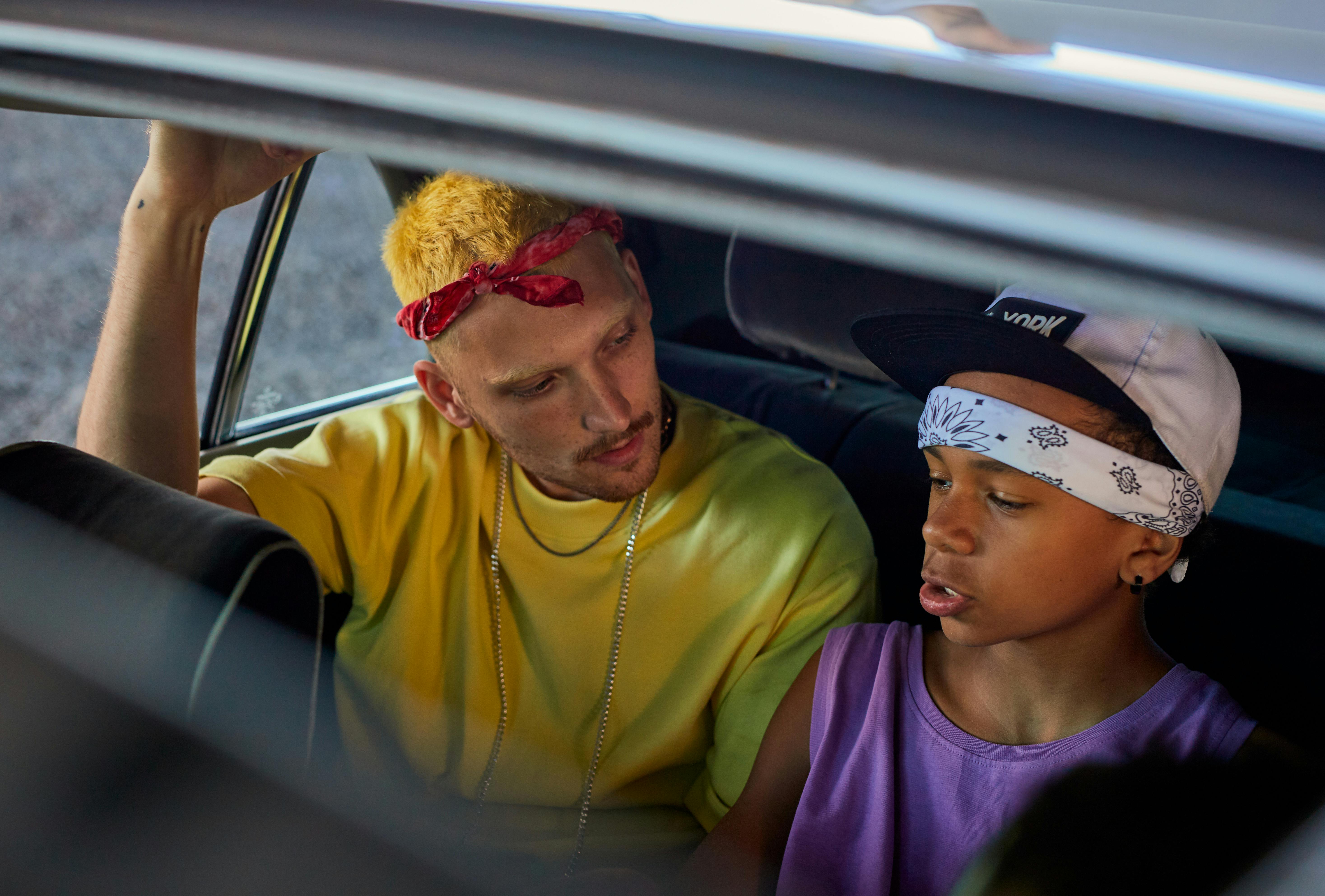 Young Men in Bandanas Sitting in the Back Seat of a Car · Free Stock Photo