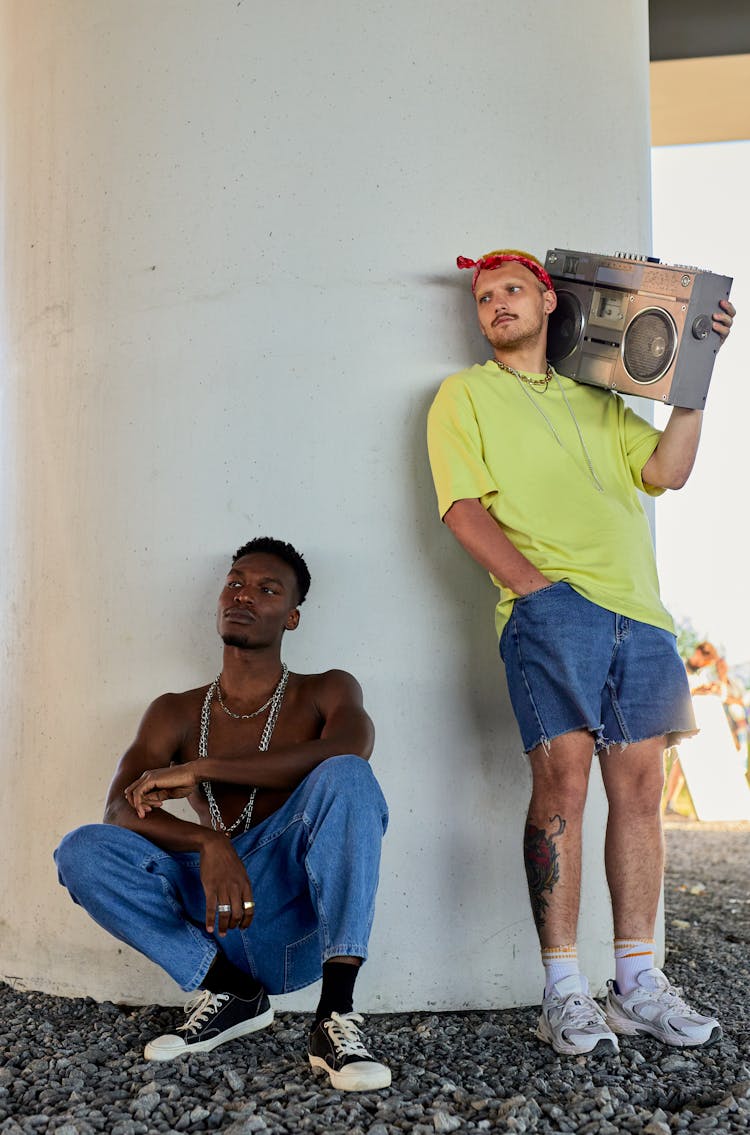 Men Listening To Music Beside A Column