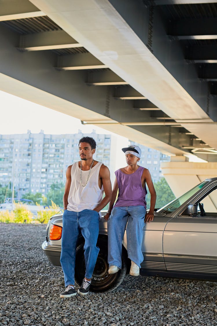 A Man And A Boy Sitting On A Silver Car