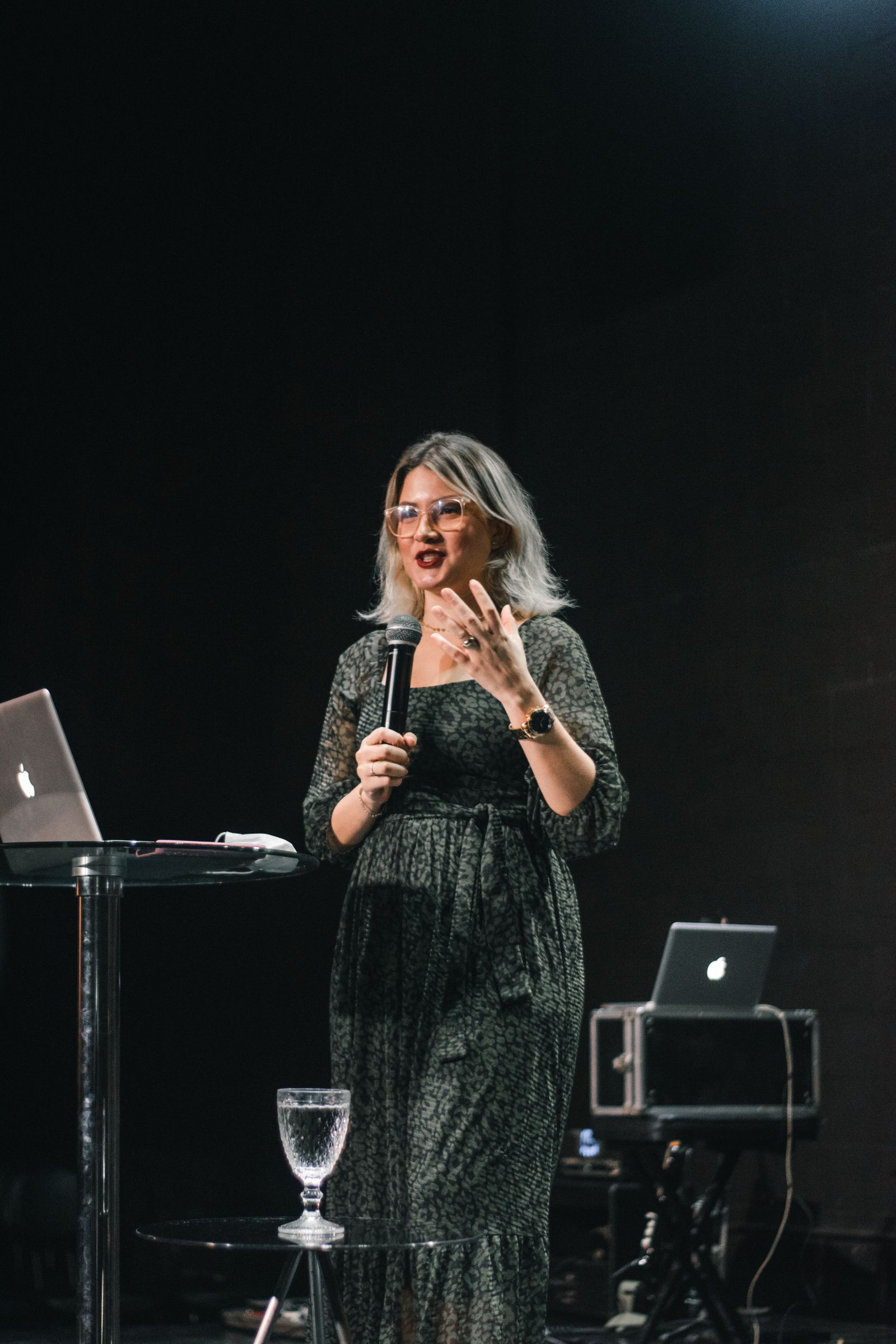 Woman speaking with a microphone on stage