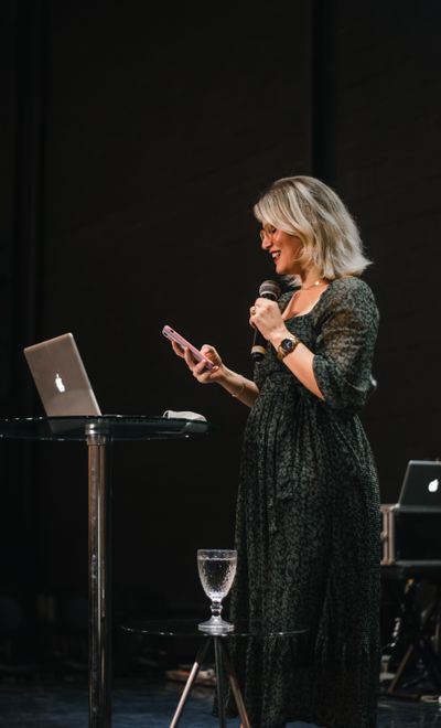 Speaker presenting with a microphone on a dark stage — photo by Igreja Dimensão on Pexels