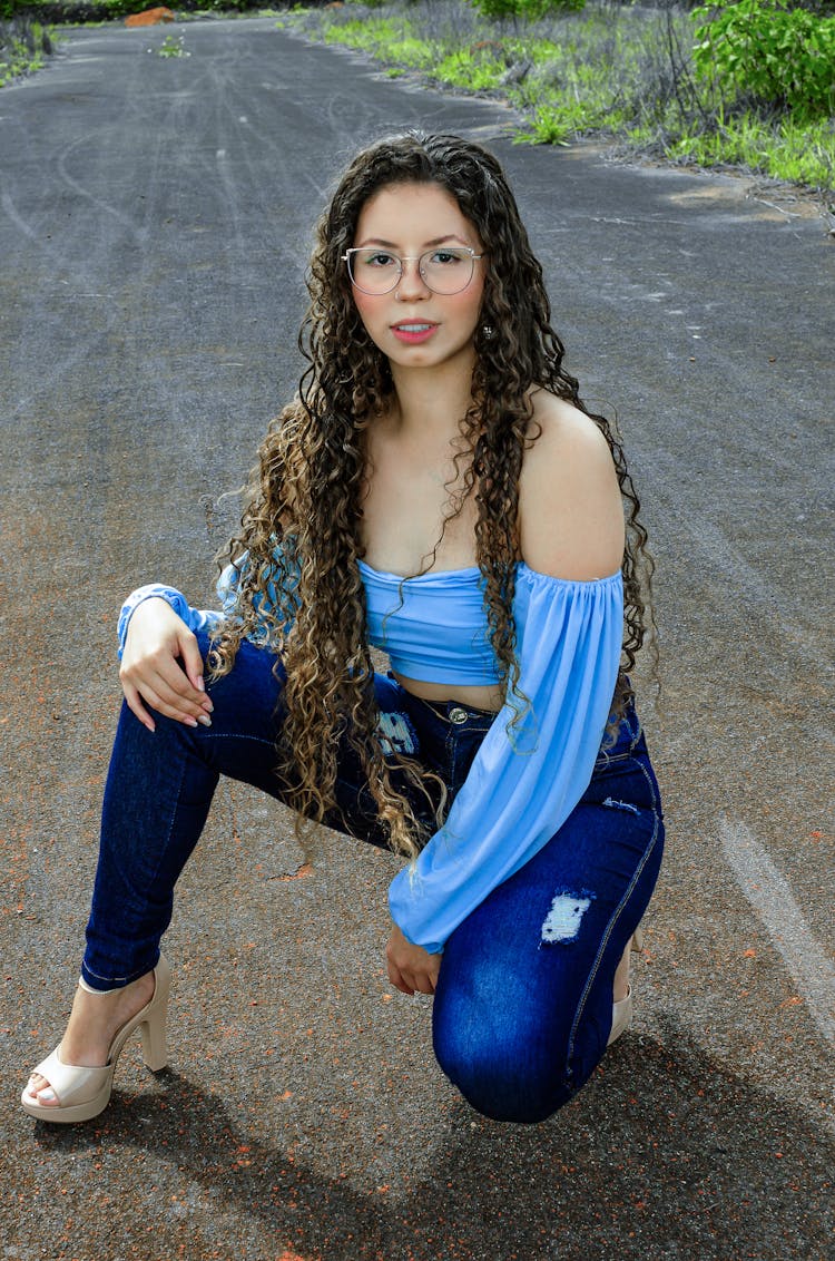 Woman Posing In Off Shoulder Blouse And Denim Pants