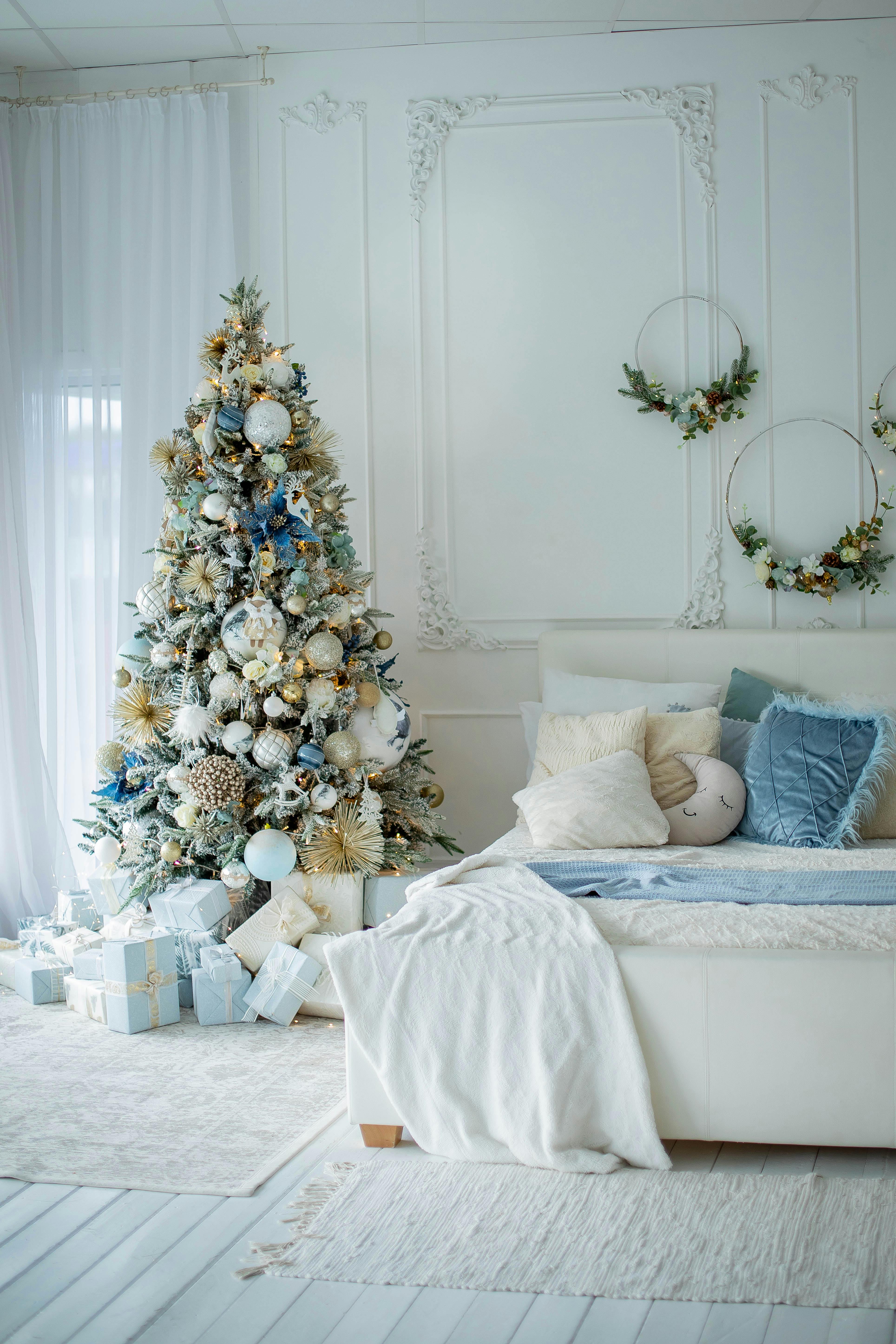christmas tree and wall decorations in bedroom arranged in white and blue