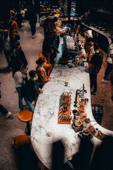 High angle view of people in a bustling coffee shop with a focus on a marble bar and chess set.