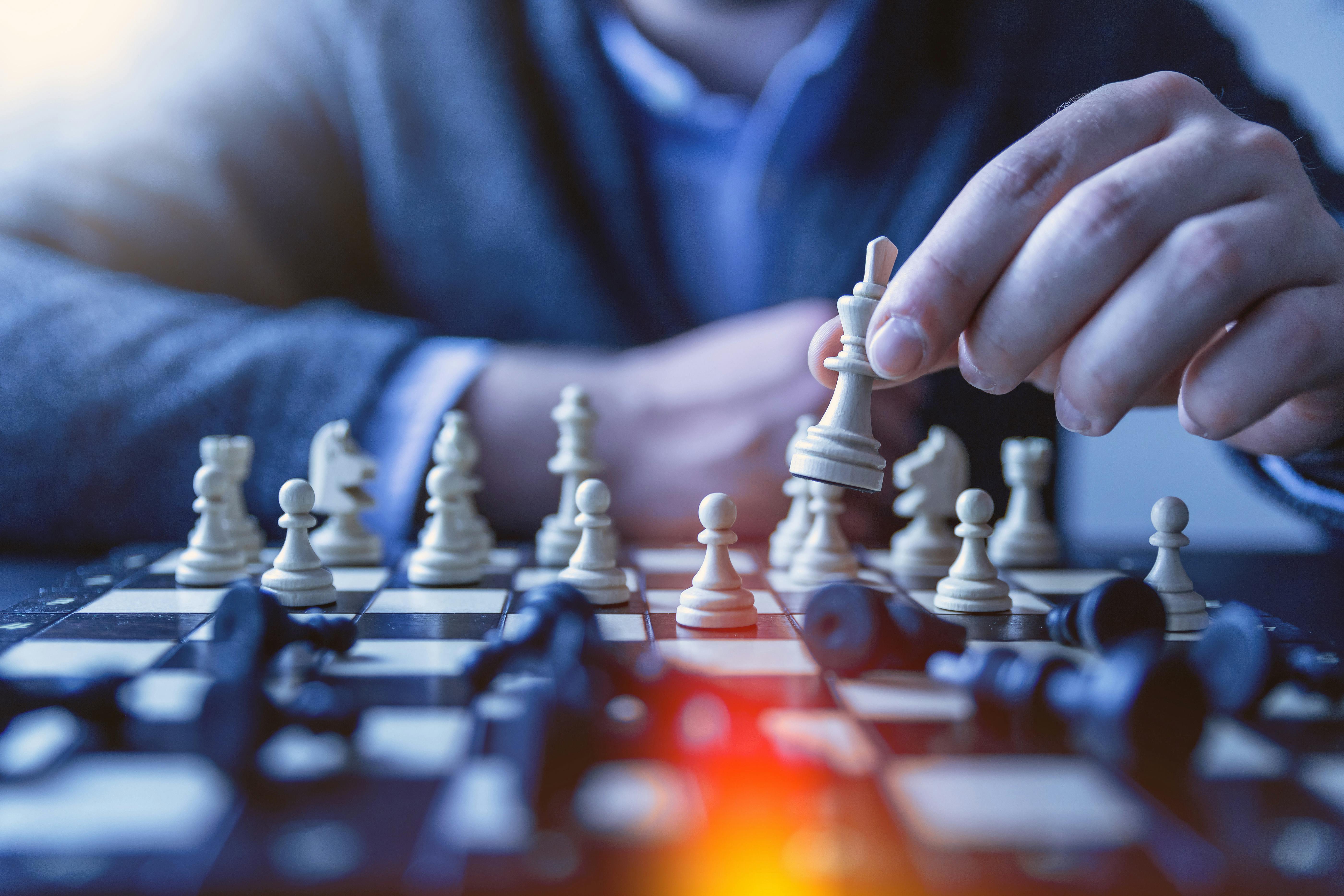 Download A Person Is Playing Chess On A Board Wallpaper