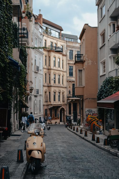 Free Explore an enchanting cobblestone street in Istanbul, adorned with a vintage scooter and historic architecture. Stock Photo