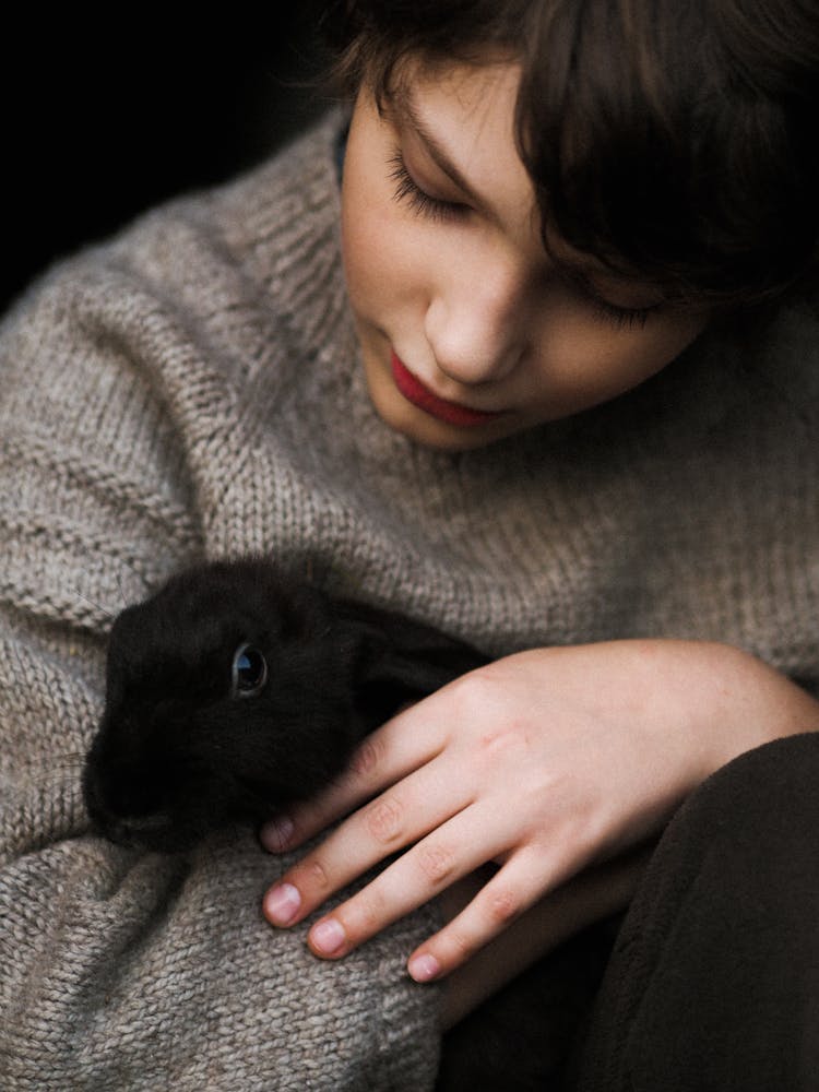 Portrait Of Woman Hugging Black Pet Bunny