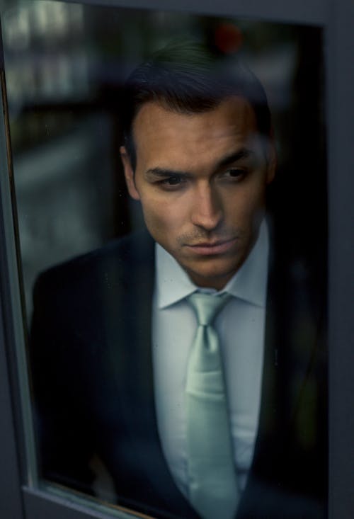 Man in Suit Looking through the Window
