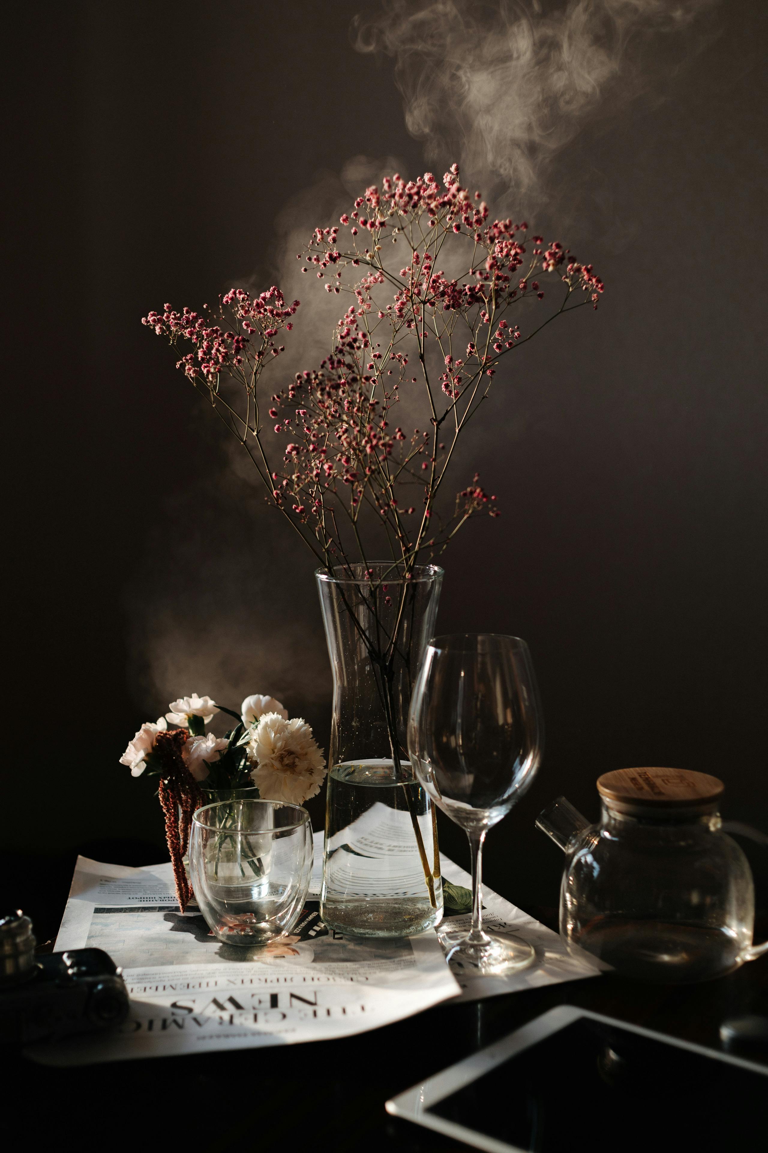 Free Glass Utensils and Cut Flowers in Artistic Arrangement with Smoke in Background Stock Photo