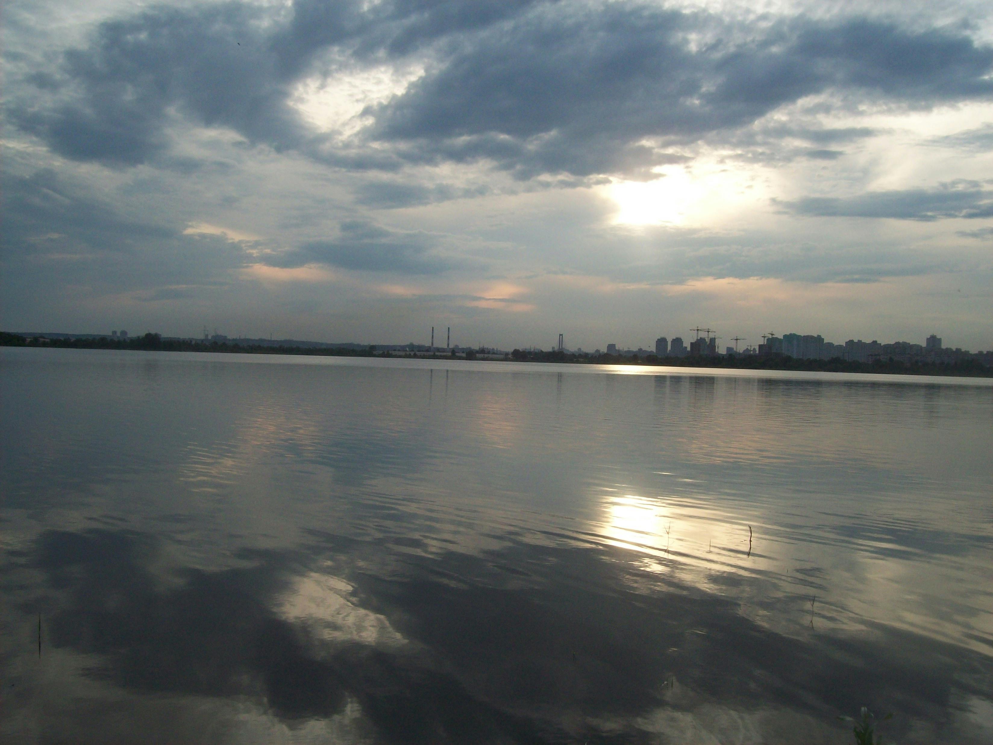 Soft white feather held delicately against smooth skin in low intimate light, evoking teasing sensual touch and hypnotic anticipation