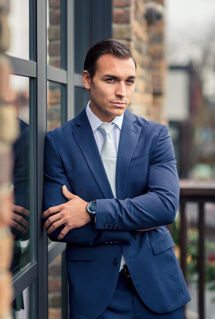 Man In Suit Leaning Against The Window