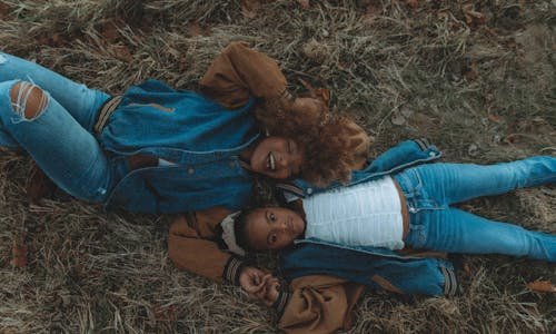 A Woman and a Girl Lying Down on Grass Field