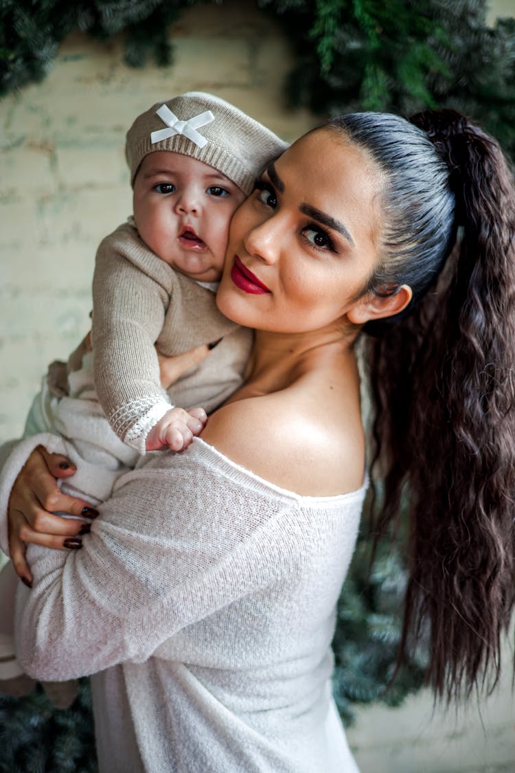 Portrait Of A Pretty Brunette Holding A Baby