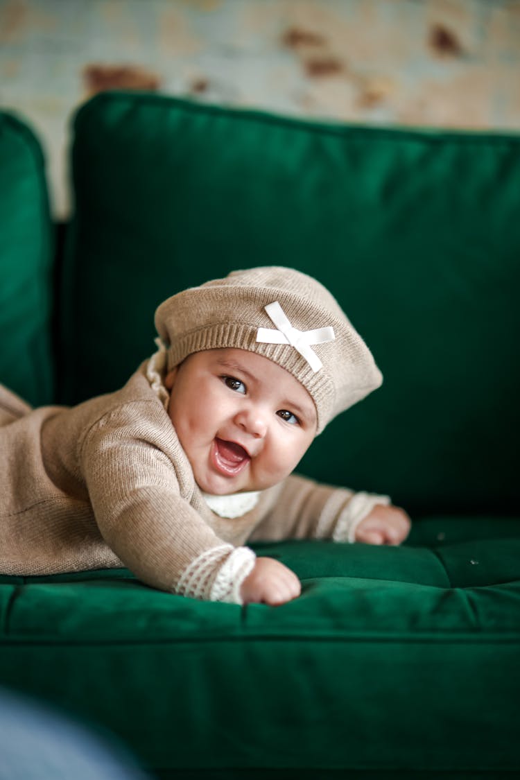 Smiling Baby Infant Lying On Couch