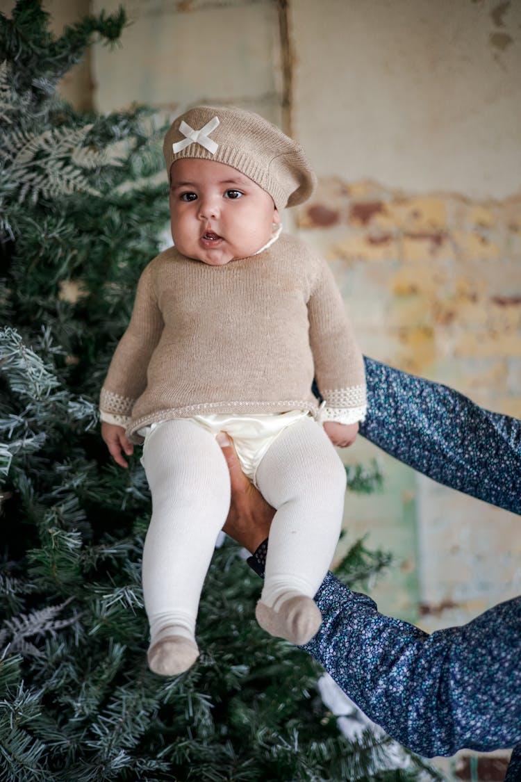 Little Baby Girl Next To A Christmas Tree